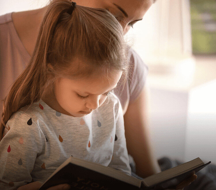 Mère et fille lisant un livre.